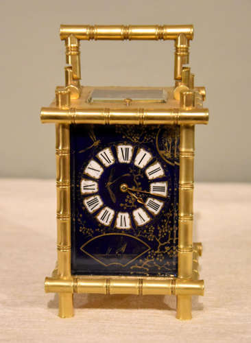 A rare porcelain mounted carriage clock in bamboo case