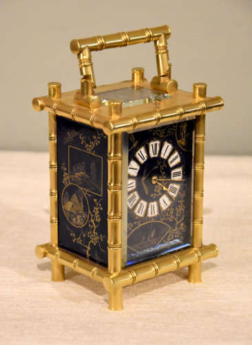 A rare porcelain mounted carriage clock in bamboo case